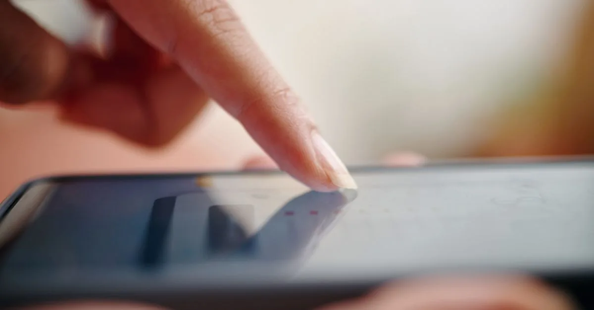 Mobilanvändning barn fritid – närbild på finger som använder mobiltelefon